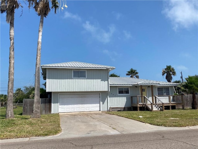 327 S Station St, Port Aransas, TX 78373 - view of front of home featuring an attached garage, concrete driveway, and metal roof