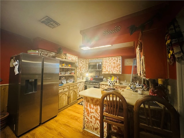 kitchen with kitchen peninsula, appliances with stainless steel finishes, and light hardwood / wood-style flooring