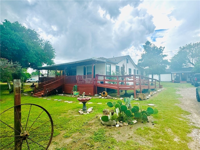 rear view of house with a lawn and a wooden deck