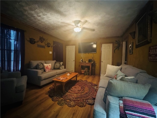 living room with ceiling fan, a textured ceiling, and dark hardwood / wood-style flooring