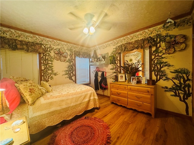 bedroom with hardwood / wood-style flooring, ceiling fan, a textured ceiling, and ornamental molding