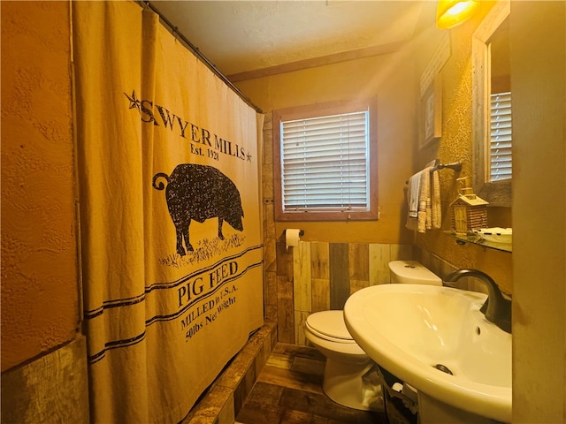 bathroom with a shower with curtain, a textured ceiling, sink, and toilet