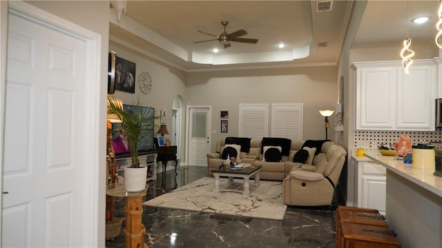 2705 Quebec Dr, Corpus Christi, TX 78414 - living room with arched walkways, ceiling fan, a tray ceiling, and crown molding