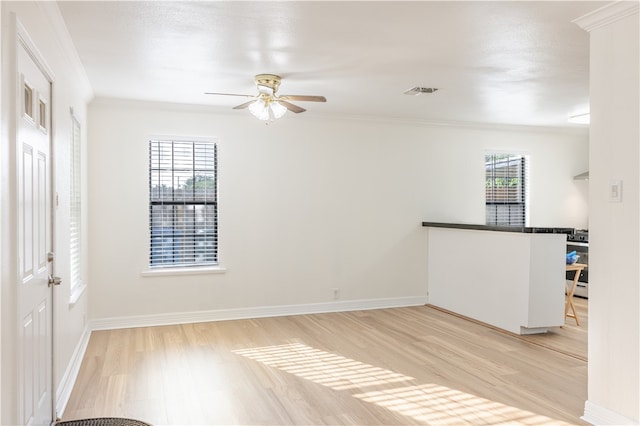 spare room featuring ceiling fan, light wood-type flooring, and ornamental molding