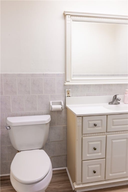 bathroom featuring hardwood / wood-style floors, vanity, toilet, and tile walls