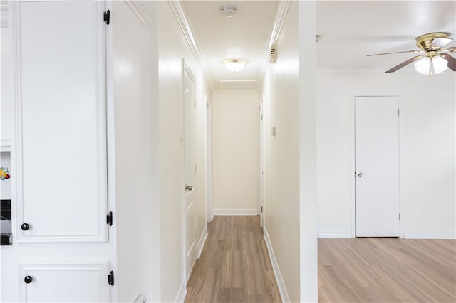 hall with light hardwood / wood-style floors and crown molding