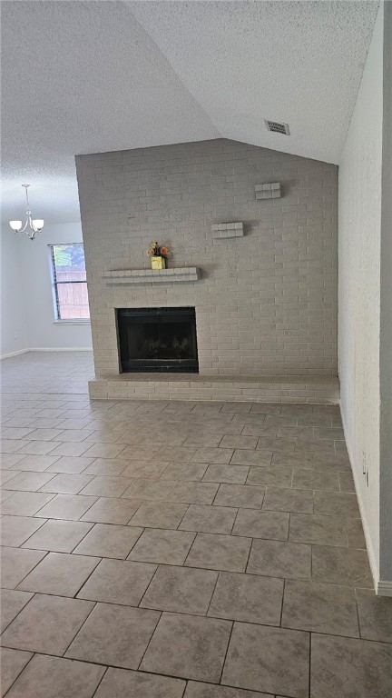4433 Aspen Grove Dr, Corpus Christi, TX 78413 - unfurnished living room with a fireplace, vaulted ceiling, a chandelier, and a textured ceiling