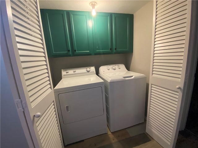 laundry area featuring a textured ceiling, dark hardwood / wood-style flooring, washing machine and dryer, and cabinets