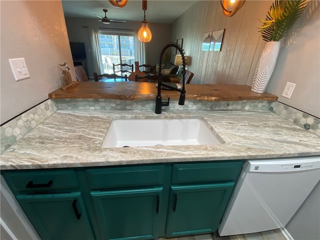 kitchen featuring white dishwasher, green cabinets, sink, ceiling fan, and pendant lighting