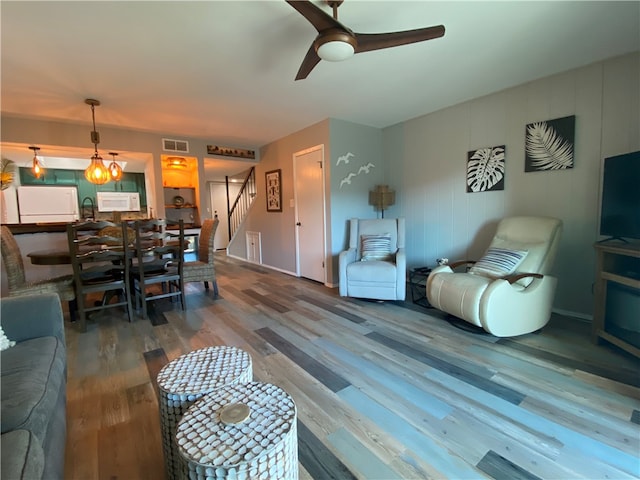 living room featuring wood-type flooring and ceiling fan