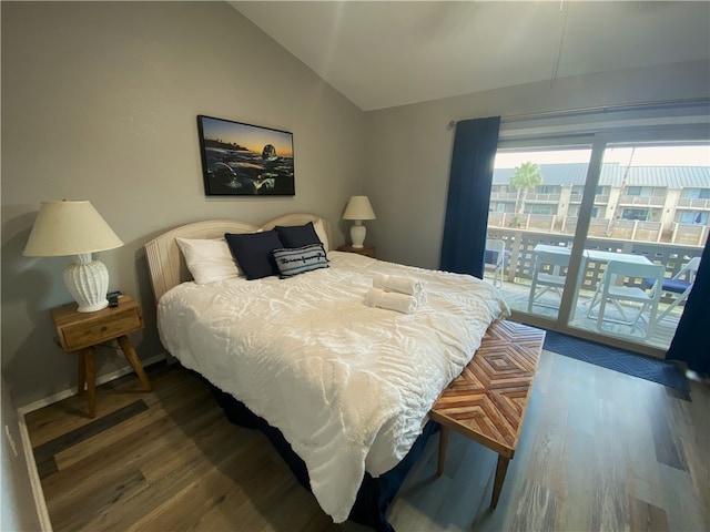 bedroom with dark hardwood / wood-style flooring, lofted ceiling, and access to exterior