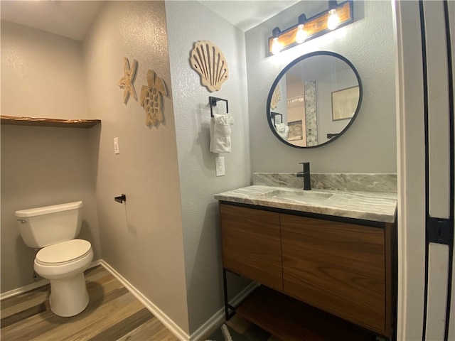 bathroom with hardwood / wood-style floors, vanity, and toilet