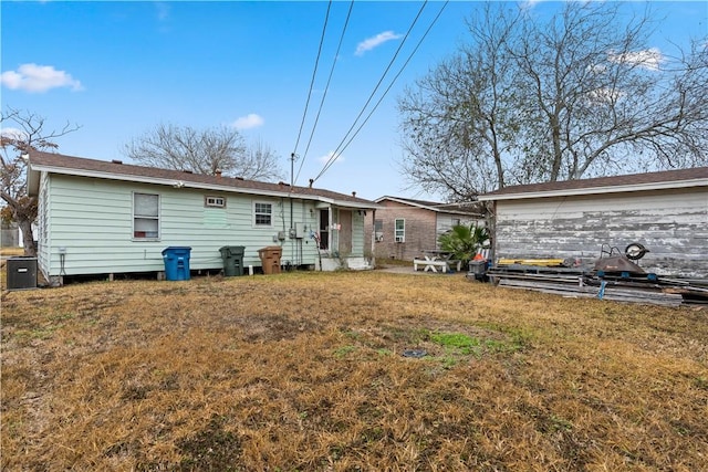 rear view of property featuring a yard and cooling unit