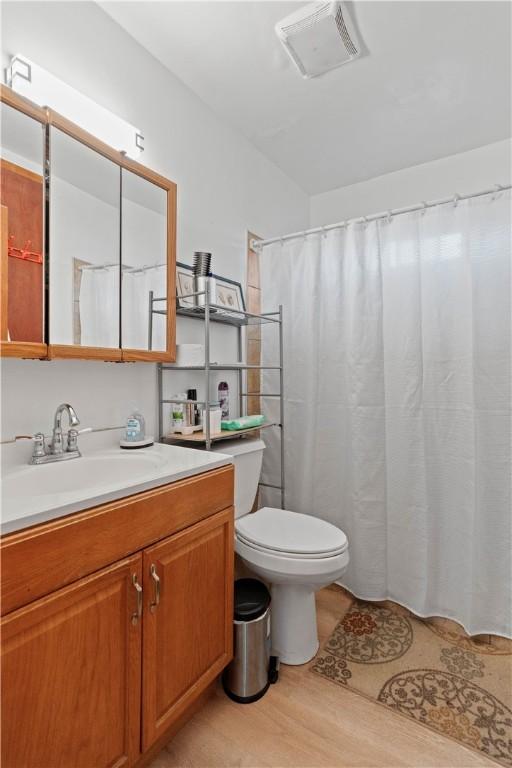 bathroom featuring hardwood / wood-style flooring, vanity, and toilet