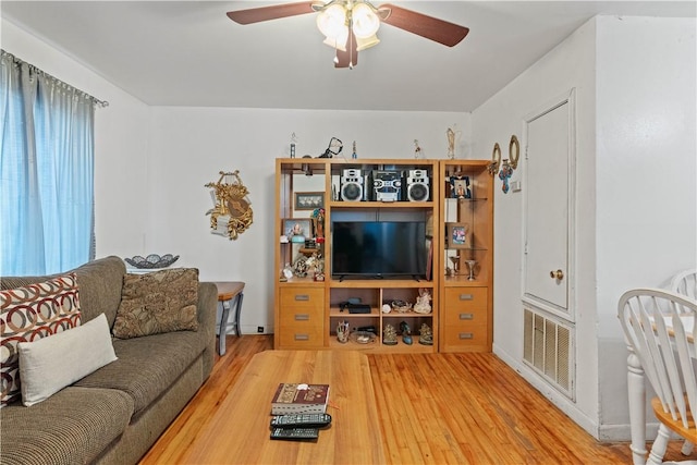 living room with wood-type flooring and ceiling fan