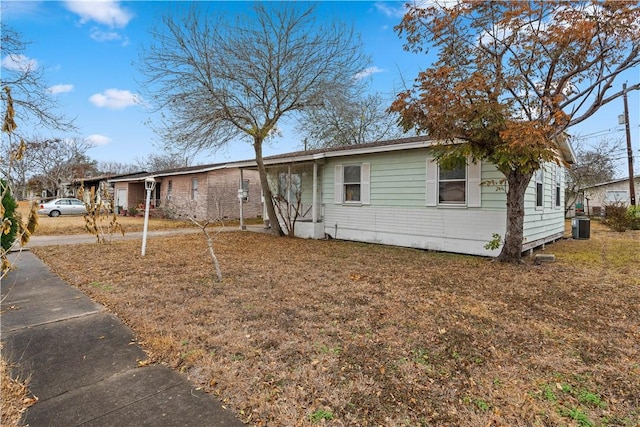 view of front facade with central AC unit and a front yard