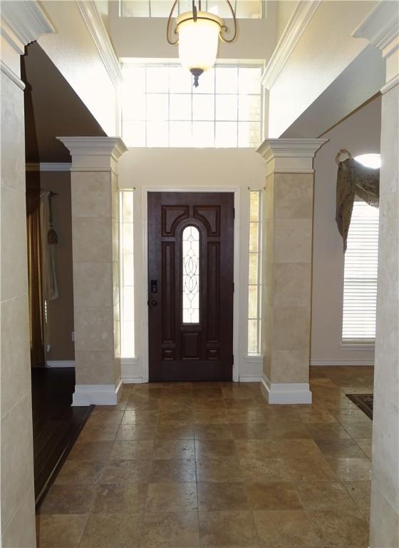 foyer entrance with decorative columns and a high ceiling