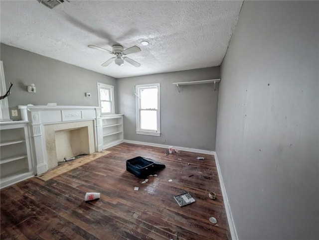 unfurnished living room with visible vents, a ceiling fan, a textured ceiling, wood finished floors, and baseboards