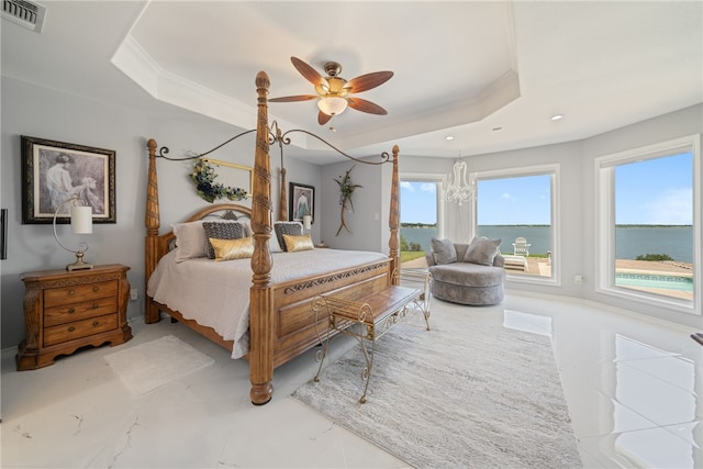 bedroom featuring a water view, a raised ceiling, and ceiling fan with notable chandelier