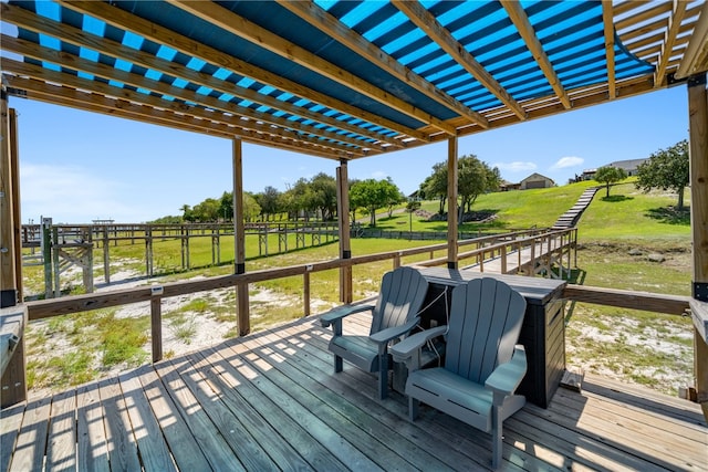 wooden terrace with a yard, a pergola, and a rural view