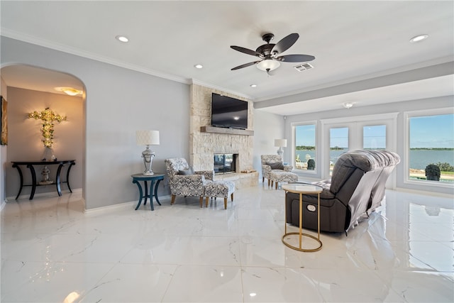 living room with a fireplace, ceiling fan, and crown molding