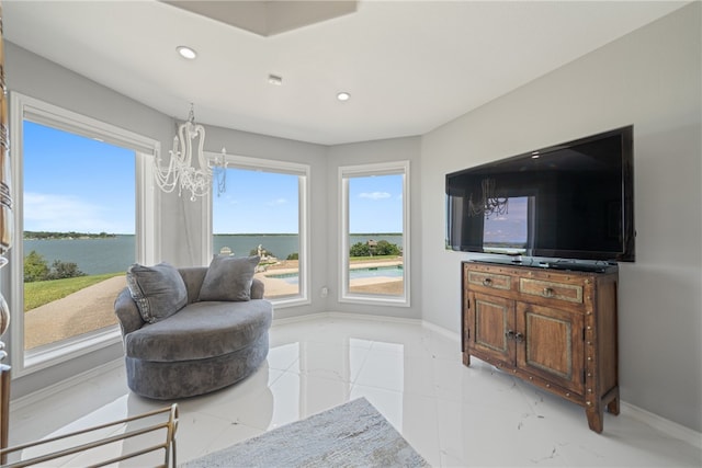 living area with a water view and a notable chandelier