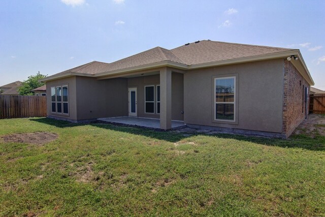 back of house with a patio and a yard