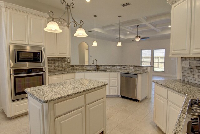 kitchen with sink, kitchen peninsula, appliances with stainless steel finishes, coffered ceiling, and pendant lighting