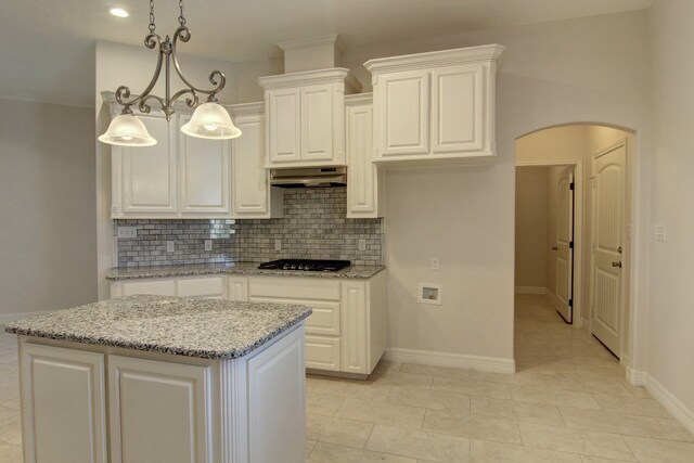 kitchen featuring black gas cooktop, light stone counters, a kitchen island, white cabinets, and pendant lighting