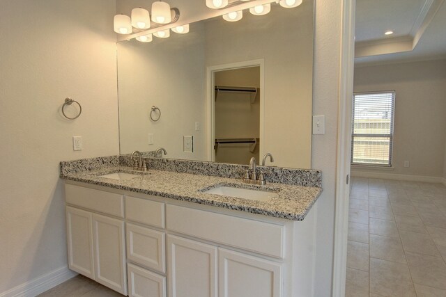 bathroom featuring tile patterned flooring, vanity, and a tray ceiling