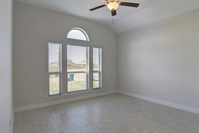 empty room featuring lofted ceiling, light tile patterned floors, ceiling fan, and plenty of natural light