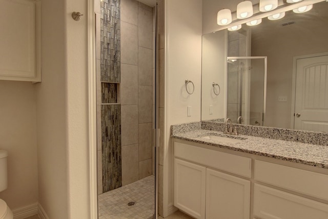 bathroom with vanity, toilet, and a shower with door