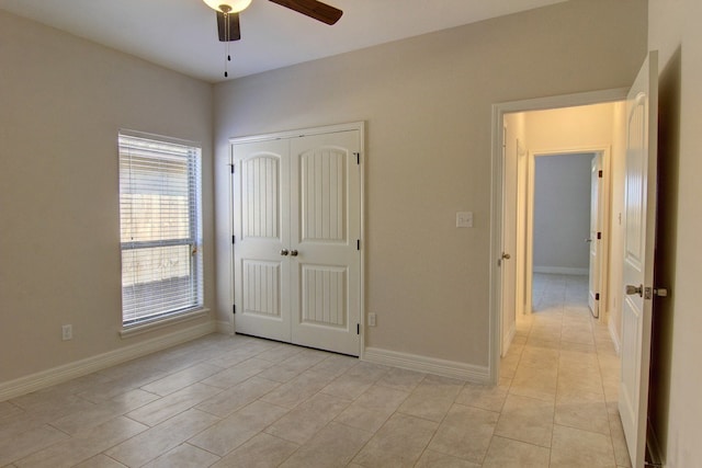 unfurnished bedroom featuring a closet, light tile patterned flooring, and ceiling fan