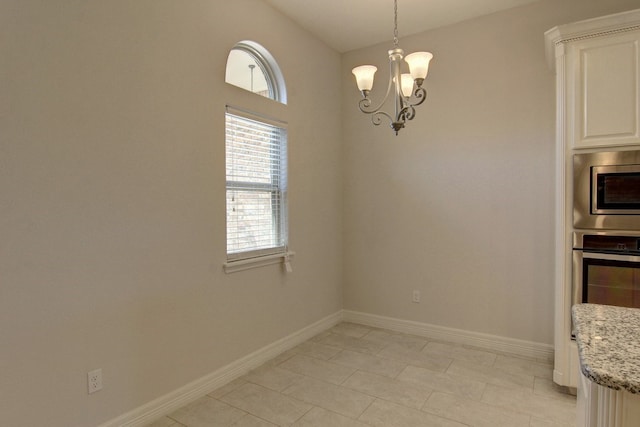 unfurnished dining area with light tile patterned floors and a notable chandelier