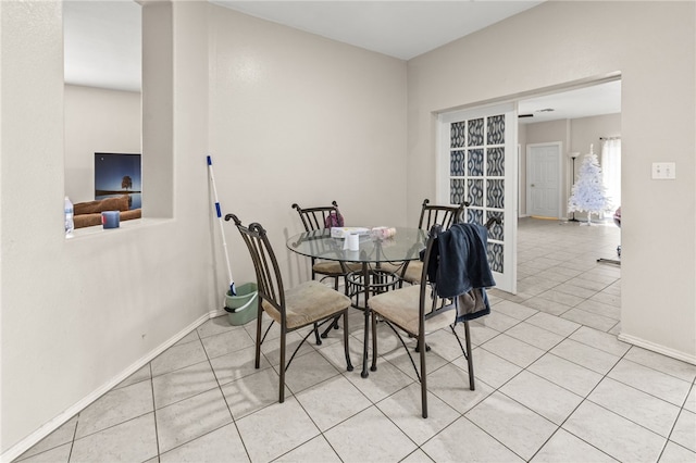 dining space featuring light tile patterned floors and baseboards