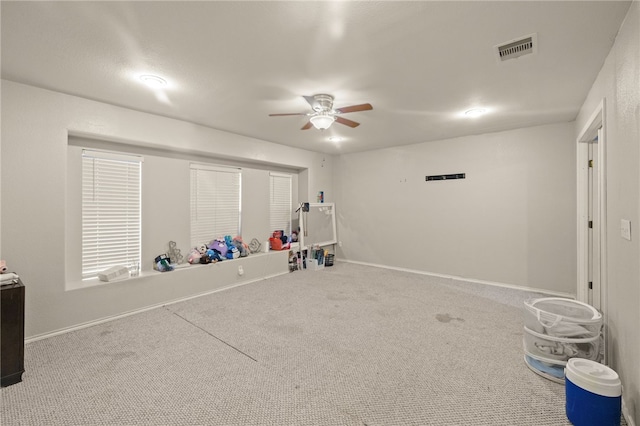 rec room with carpet, visible vents, ceiling fan, and baseboards