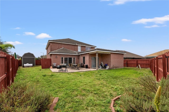 rear view of house with a lawn, a patio, a fenced backyard, an outbuilding, and a storage unit