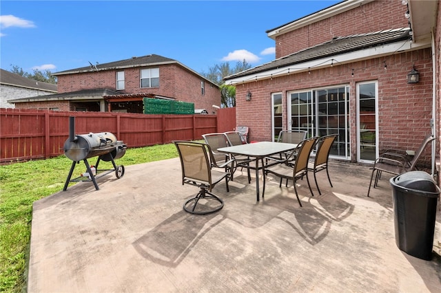 view of patio / terrace featuring outdoor dining space, a fenced backyard, and a grill