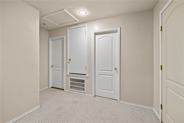 interior space with carpet flooring, attic access, and baseboards