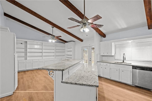 kitchen featuring white cabinets, a breakfast bar area, a center island, stainless steel dishwasher, and a sink