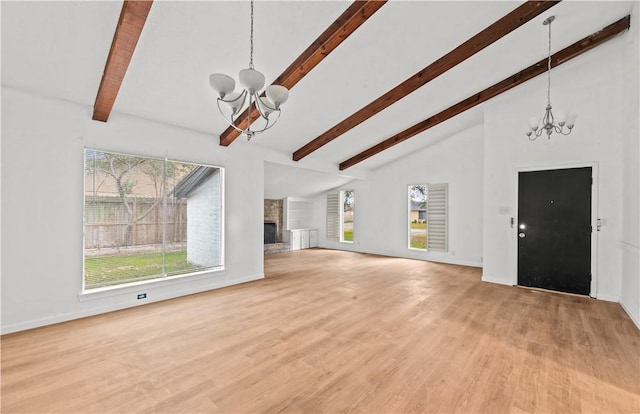 unfurnished living room featuring a fireplace with raised hearth, high vaulted ceiling, a notable chandelier, light wood finished floors, and beamed ceiling