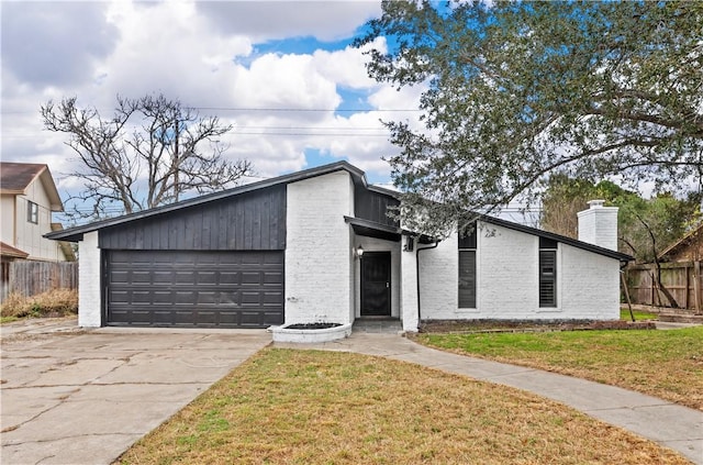 mid-century home with brick siding, a chimney, a front yard, and fence