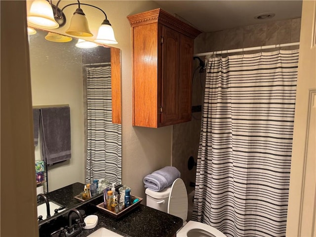 bathroom featuring toilet, curtained shower, and vanity