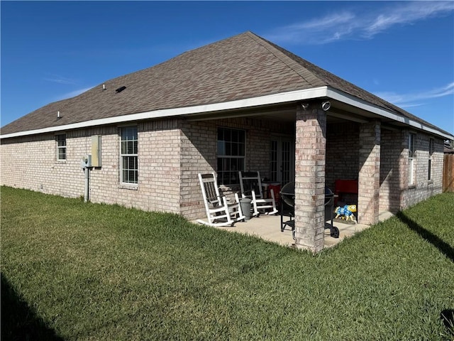 back of house with a patio and a lawn