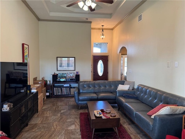 living room featuring ceiling fan, crown molding, a raised ceiling, and a towering ceiling