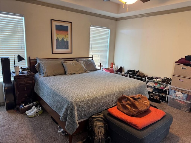 carpeted bedroom with multiple windows, ceiling fan, and ornamental molding