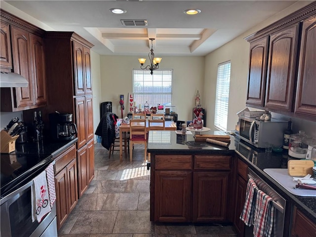 kitchen featuring a notable chandelier, stainless steel appliances, pendant lighting, and a tray ceiling