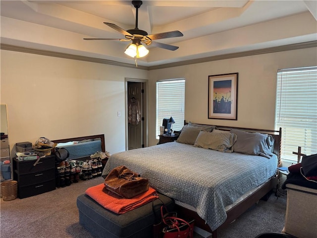 carpeted bedroom with ornamental molding, a raised ceiling, and ceiling fan