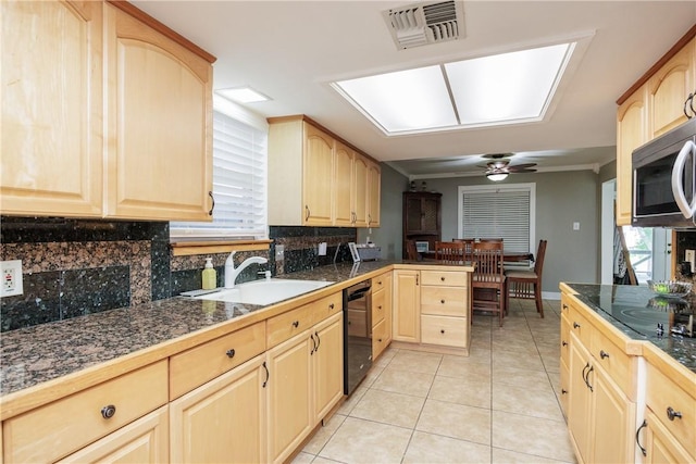 3346 Samoa Dr, Corpus Christi, TX 78418 - kitchen with light brown cabinets, black dishwasher, tasteful backsplash, stainless steel microwave, and a ceiling fan