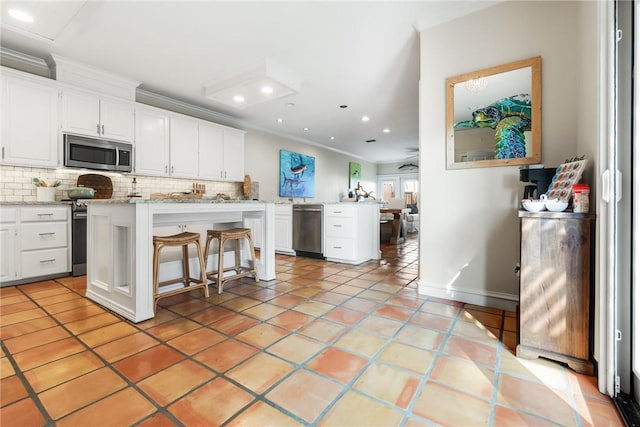 kitchen with ornamental molding, stainless steel appliances, and tasteful backsplash